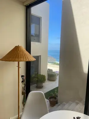 a table with a chair and a umbrella and the ocean at La Jolla Suite & Beach Access in San Diego