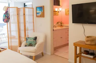 a living room with a white chair and a television at La Jolla Suite & Beach Access in San Diego