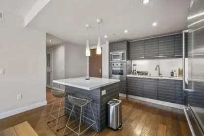 a kitchen with black and white appliances and a counter at Little Italy Marina Condo by the Ocean in San Diego