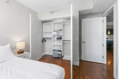 a bedroom with a white bed and a closet at Little Italy Marina Condo by the Ocean in San Diego