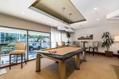 a pool table in a room with a large window at Little Italy Marina Condo by the Ocean in San Diego