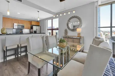 a dining room and kitchen with a glass table and chairs at Gaslamp 2 bed Penthouse Petco Park Convention Ctr in San Diego