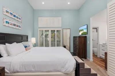 a bedroom with a large white bed and a bathroom at Breeze & Bridle - TC530J in Solana Beach
