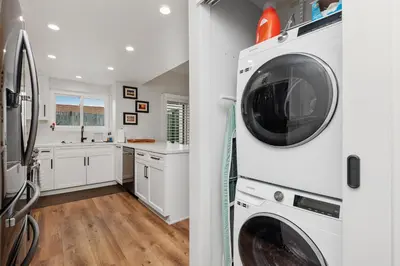 a kitchen with white cabinets and a washer and dryer at Breeze & Bridle - TC530J in Solana Beach