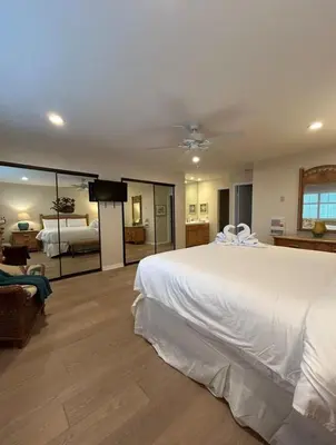 a bedroom with a large white bed and a living room at Coastal Heights - DMBC857C in Solana Beach