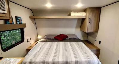 a small bedroom with a bed in a trailer at The Owl House in Spring Valley