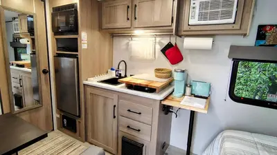 a small kitchen in an rv with a sink at The Owl House in Spring Valley