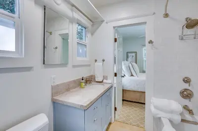 a white bathroom with a sink and a bed at half Mi to Balboa Park Cottage with Private Yard! in San Diego