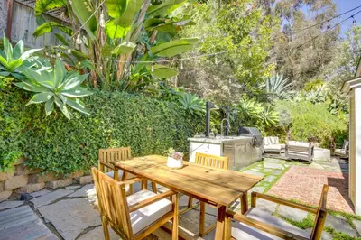 a patio with a wooden table and chairs and a grill at half Mi to Balboa Park Cottage with Private Yard! in San Diego