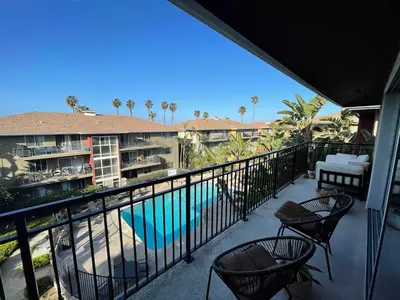 a balcony with chairs and a swimming pool at beachside condo in the heart of Bird Rock La Jolla in San Diego