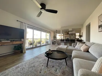 a living room with a couch and a flat screen tv at beachside condo in the heart of Bird Rock La Jolla in San Diego