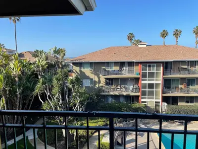 a view from the balcony of a hotel with palm trees at beachside condo in the heart of Bird Rock La Jolla in San Diego