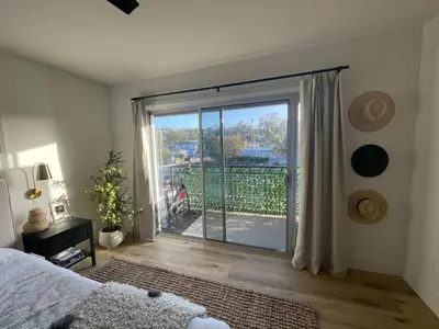 a bedroom with a sliding glass door with a balcony at beachside condo in the heart of Bird Rock La Jolla in San Diego