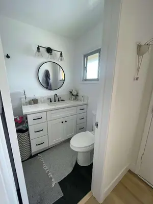 a bathroom with a white toilet and a mirror at beachside condo in the heart of Bird Rock La Jolla in San Diego