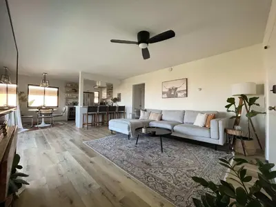 a living room with a couch and a ceiling fan at beachside condo in the heart of Bird Rock La Jolla in San Diego