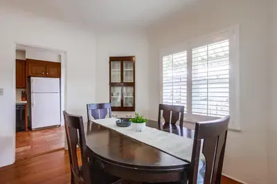 a dining room with a table and chairs and a kitchen at Spring break 2 blocks to beach pier Newport Ave in San Diego