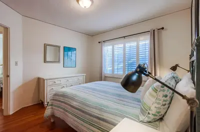a bedroom with a bed and a desk with a lamp at Spring break 2 blocks to beach pier Newport Ave in San Diego