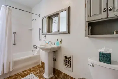a white bathroom with a sink and a toilet at Spring break 2 blocks to beach pier Newport Ave in San Diego