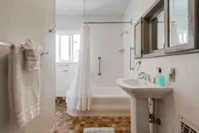 a white bathroom with a tub and a sink at Spring break 2 blocks to beach pier Newport Ave in San Diego