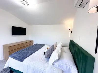 a bedroom with a bed with a tv on the wall at Oceanside Rooftop Retreat Sleeps 4 in Oceanside