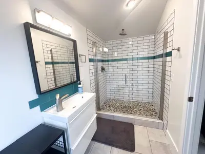 a white bathroom with a sink and a shower at Oceanside Rooftop Retreat Sleeps 4 in Oceanside