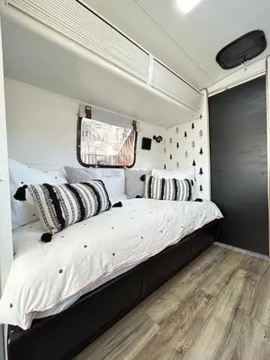 a bed in a trailer with black and white pillows at Stay in Style - Airstream & Views in Spring Valley