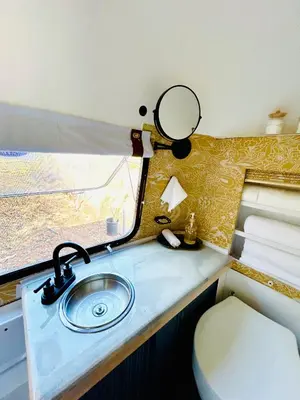 a bathroom with a sink and a mirror at Stay in Style - Airstream & Views in Spring Valley