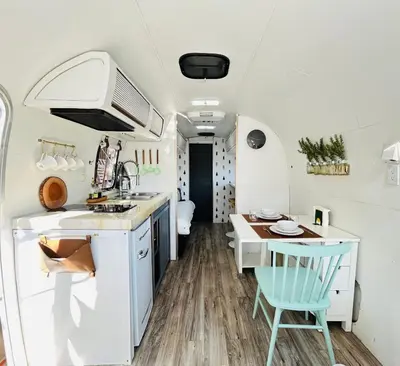 a kitchen and dining area of an rv at Stay in Style - Airstream & Views in Spring Valley