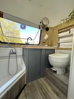 a bathroom with a toilet and a tub and a sink at Stay in Style - Airstream & Views in Spring Valley