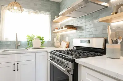a kitchen with white cabinets and a stove top oven at Chic Surf Lodge with Hot Tub & Ocean Views in Oceanside