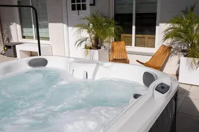 a jacuzzi tub on a patio with two chairs at Chic Surf Lodge with Hot Tub & Ocean Views in Oceanside