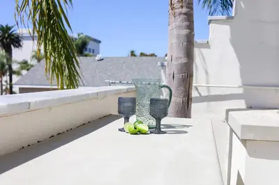a table with two vases and fruit on a balcony at Chic Surf Lodge with Hot Tub & Ocean Views in Oceanside