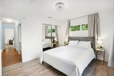 a white bedroom with a white bed and a mirror at Large 5BR Family Haven w Sports court Game Room Backyard in La Mesa
