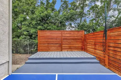 a wooden fence with a tennis court in front of it at Large 5BR Family Haven w Sports court Game Room Backyard in La Mesa
