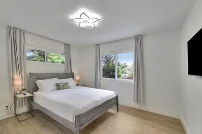 a white bedroom with a bed and two windows at Large 5BR Family Haven w Sports court Game Room Backyard in La Mesa