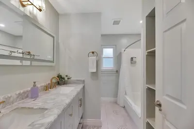 a white bathroom with a large sink and a tub at Large 5BR Family Haven w Sports court Game Room Backyard in La Mesa