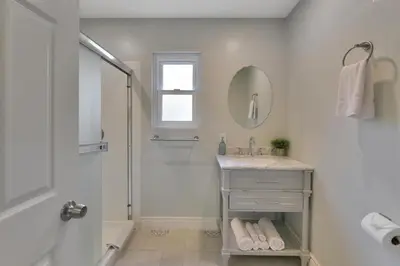 a white bathroom with a shower and a sink at Large 5BR Family Haven w Sports court Game Room Backyard in La Mesa