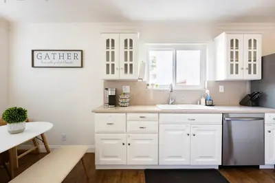 a white kitchen with white cabinets and a sink at Large 5BR Family Haven w Sports court Game Room Backyard in La Mesa