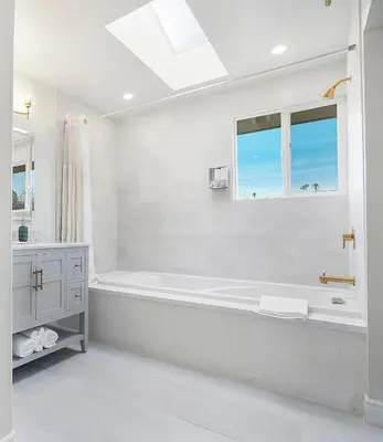 a white bathroom with a tub and a window at Large 5BR Family Haven w Sports court Game Room Backyard in La Mesa