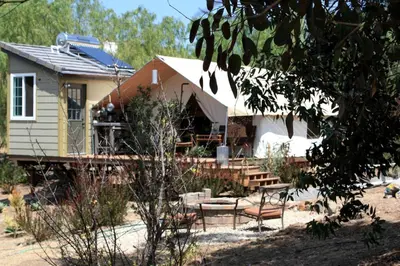 a house with a table and chairs in front of it at African-Inspired Safari Tent near San Diego for a Glamping Weekend in Vista, California in Vista