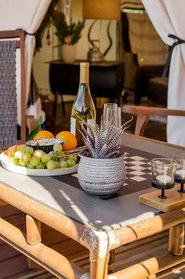 a table with a plate of fruit and a bottle of wine at African-Inspired Safari Tent near San Diego for a Glamping Weekend in Vista, California in Vista