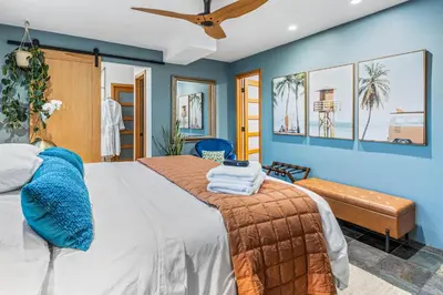 a bedroom with a large bed with blue walls at Luxurious Pool & Sauna Home with Beautiful Gardens in San Diego