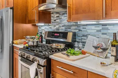 a kitchen with a stove and a counter top at Luxurious Pool & Sauna Home with Beautiful Gardens in San Diego