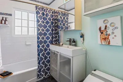 a bathroom with a sink and a shower curtain at Luxurious Pool & Sauna Home with Beautiful Gardens in San Diego