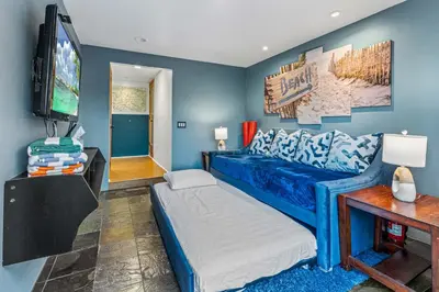 a blue room with a bed and a flat screen tv at Luxurious Pool & Sauna Home with Beautiful Gardens in San Diego