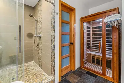 a bathroom with a shower and a glass door at Luxurious Pool & Sauna Home with Beautiful Gardens in San Diego