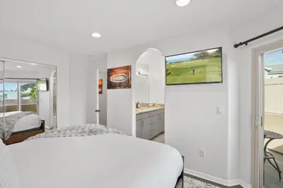 a white bedroom with a bed and a mirror at Sail Bay Luxury Retreat With Private Spa and Rooftop Bay View in San Diego