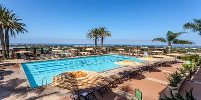 a large swimming pool with umbrellas and chairs at Grand Pacific Palisades in Carlsbad