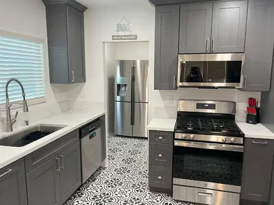 a kitchen with gray cabinets and a stove top oven at Wise in San Diego