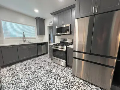 a kitchen with stainless steel appliances and a tile floor at Wise in San Diego